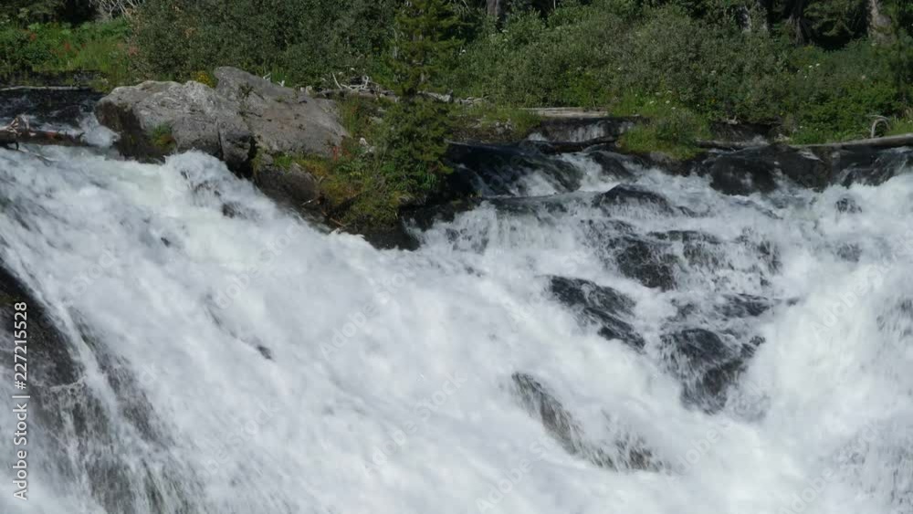 Steady close up shot of the water cascading down from the top of the Lewis Falls at the Yellowstone National Park, Wyoming. Steady close up shot of the water cascading down from the top of the Lewis Falls at the Yellowstone National Park, Wyoming.