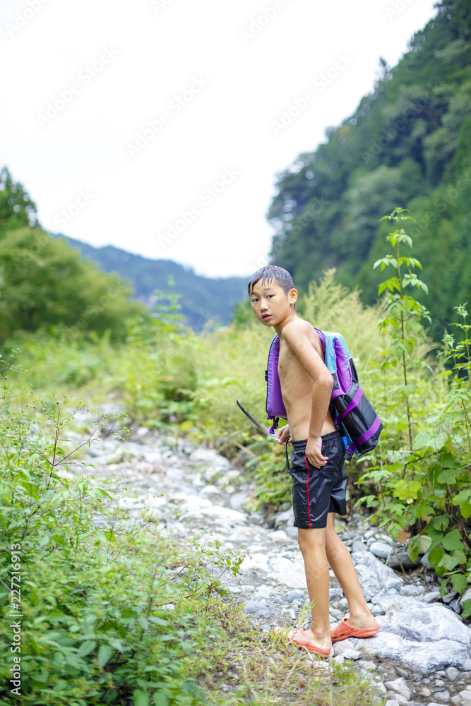 Boy wearing swimming trunks on path