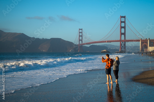 A couple at Baker Beach, San Francisco Overlooking Golden Gate Bridge