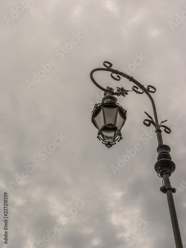 A retro lampost at a dark sky with clouds