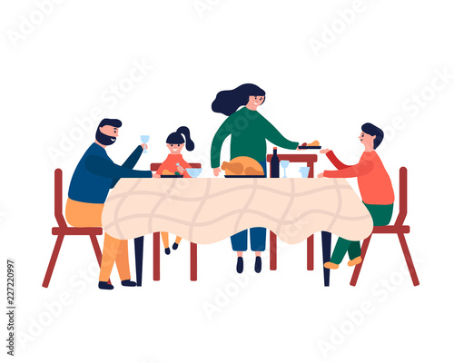 Happy family sitting at dinner table and eating turkey