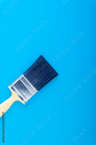 Paint brush on blue colour background with selective focus and crop fragment. Copy space conceptual