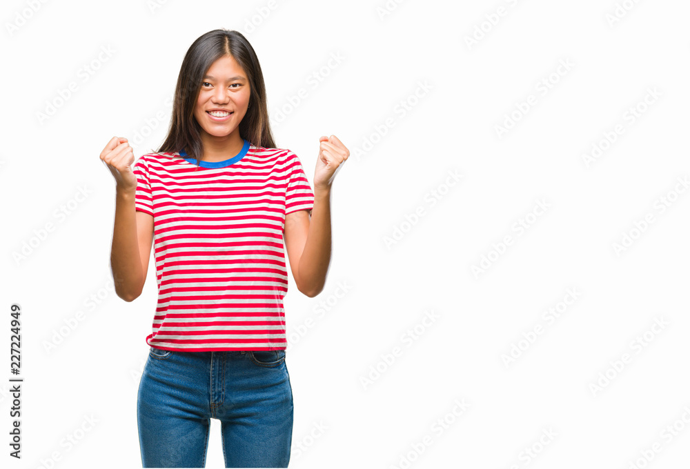 Young asian woman over isolated background celebrating surprised and amazed for success with arms raised and open eyes. Winner concept. Young asian woman over isolated background celebrating surprised and amazed for success with arms raised and open eyes. Winner concept.
