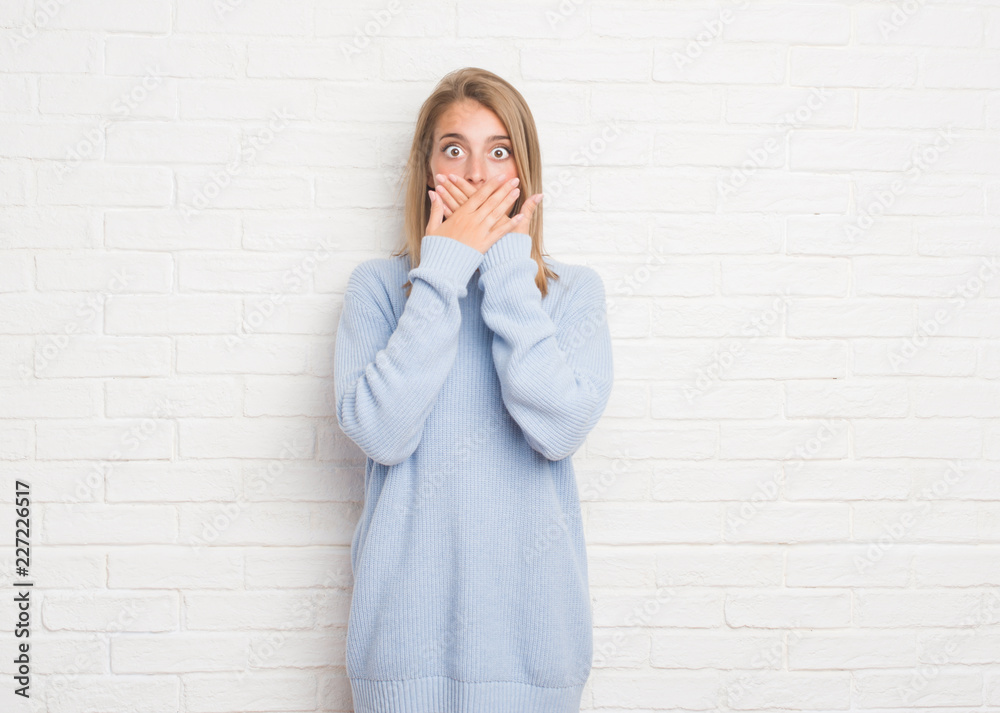 Beautiful young woman over white brick wall shocked covering mouth with hands for mistake. Secret concept. Beautiful young woman over white brick wall shocked covering mouth with hands for mistake. Secret concept.