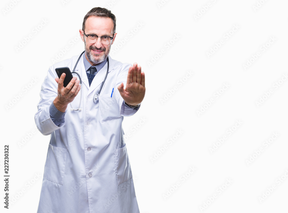 Middle age senior hoary doctor man texting using smartphone over isolated background with open hand doing stop sign with serious and confident expression, defense gesture Middle age senior hoary doctor man texting using smartphone over isolated background with open hand doing stop sign with serious and confident expression, defense gesture