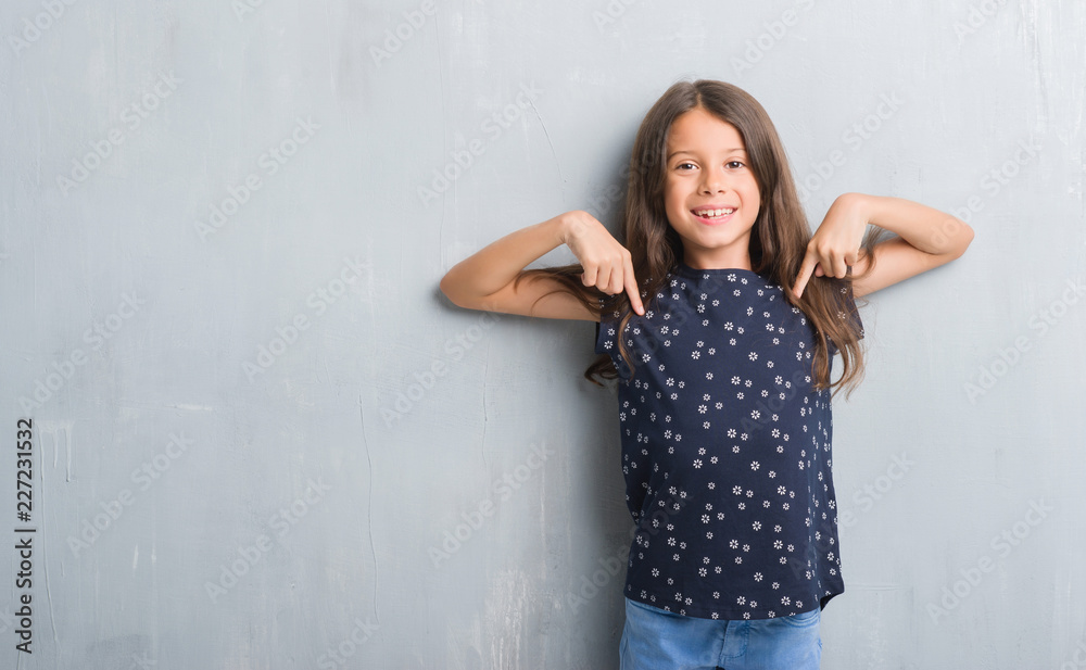 Young hispanic kid over grunge grey wall looking confident with smile on face, pointing oneself with fingers proud and happy. Young hispanic kid over grunge grey wall looking confident with smile on face, pointing oneself with fingers proud and happy.