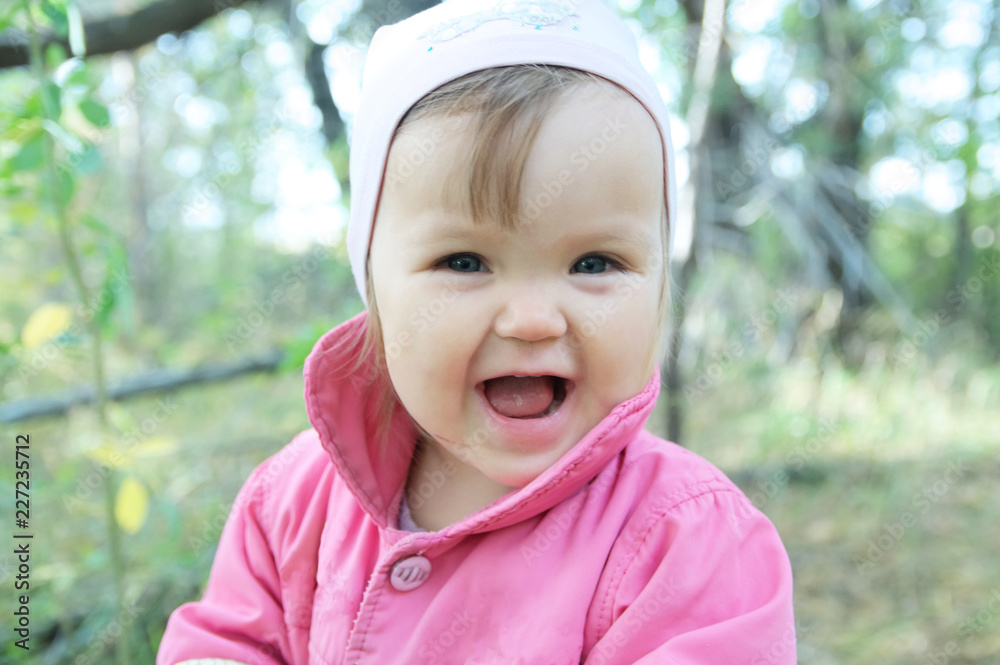 Cute baby girl happy smiling portrait. Adorable emotional child outdoor in park Cute baby girl happy smiling portrait. Adorable emotional child outdoor in park
