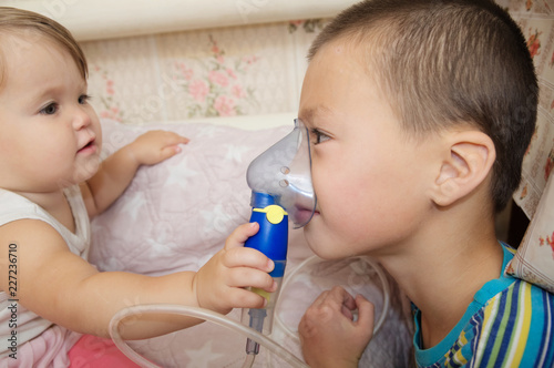 sick children - baby girl and boy use nebulizer mask for inhalation  respiratory procedure by pneumonia or cough for child  inhaler  compressor nebulizer  nebules machine for health care