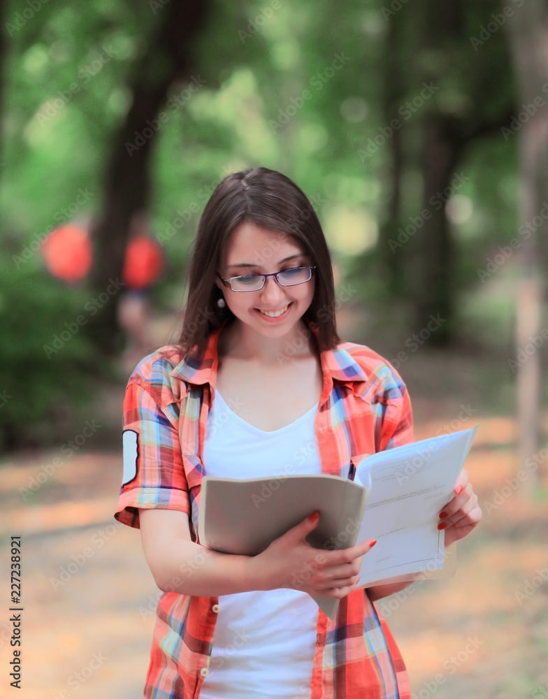 smiling student girl with a clipboard on the background of the Park smiling student girl with a clipboard on the background of the Park