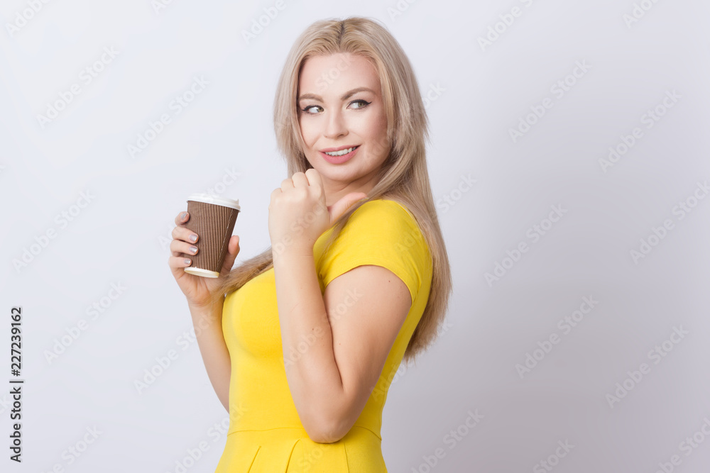 Blonde woman holding coffee cup in her hands Blonde woman holding coffee cup in her hands