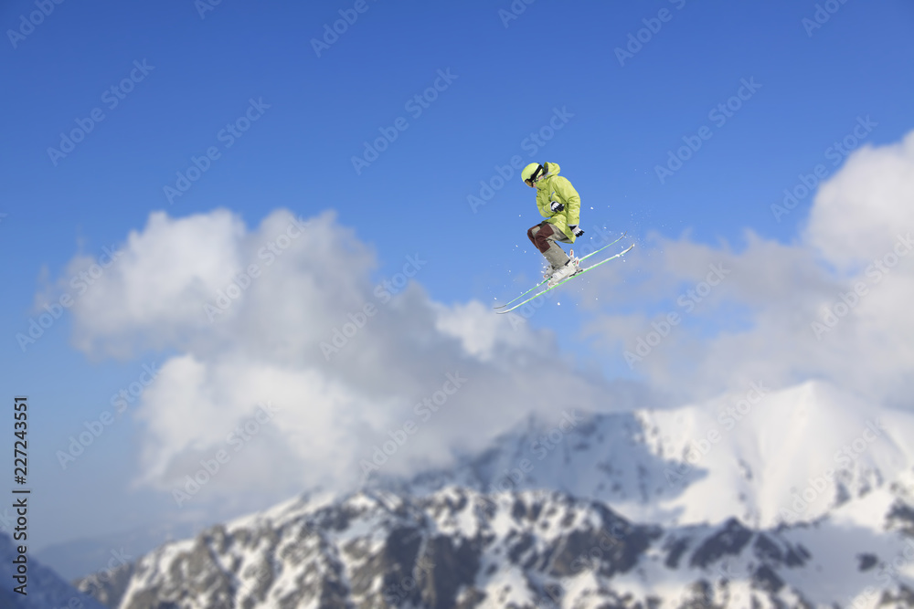 Flying skier on mountains. Extreme winter sport.