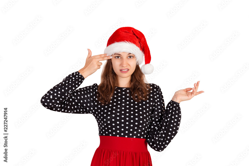 Annoyed and displeased woman in dress shrugging and holding fingers on temple. emotional girl in santa claus christmas hat isolated on white background. holiday concept Annoyed and displeased woman in dress shrugging and holding fingers on temple. emotional girl in santa claus christmas hat isolated on white background. holiday concept