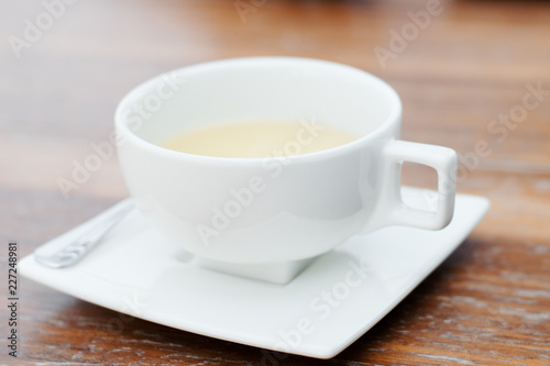White cup of tea on wooden table. Tea drinking
