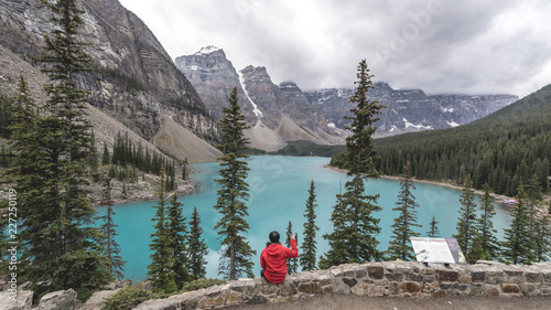 A man sitting and looking a scenic view of Moraine Lake © sittichana