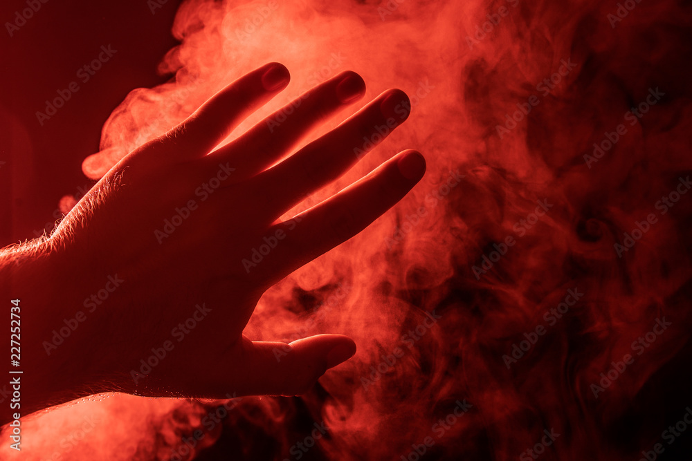 Hand on the background of red steam.