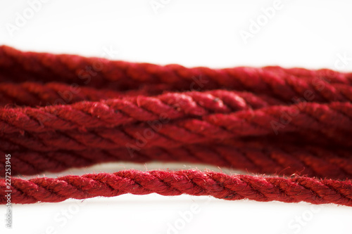 One skein of jute rope six millimeters for Japanese bondage and shibari, painted in red on a white background. Professionally knitted hank