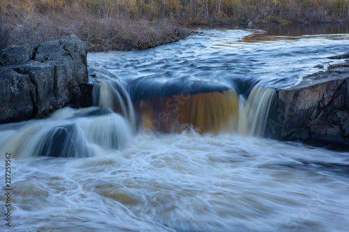 Water stream in a small waterfall among rocks 