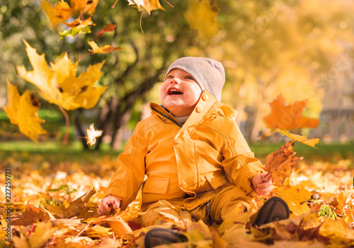 Kids play in autumn park. Children throwing yellow leaves.Baby with oak and maple leaf. Fall foliage. Family outdoor fun in autumn. Toddler kid or preschooler child in fall.