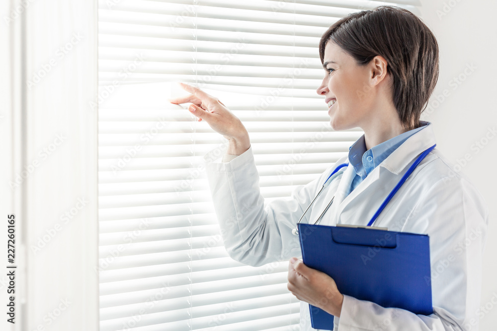 Young doctor or nurse looking through a window Young doctor or nurse looking through a window