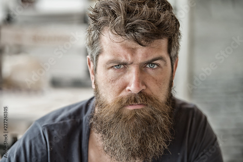 Man brutal bearded hipster thoughtful mood defocused background. Macho with beard and mustache look confident brutal. Beard represent masculinity. Brutality concept. Beard masculinity attribute