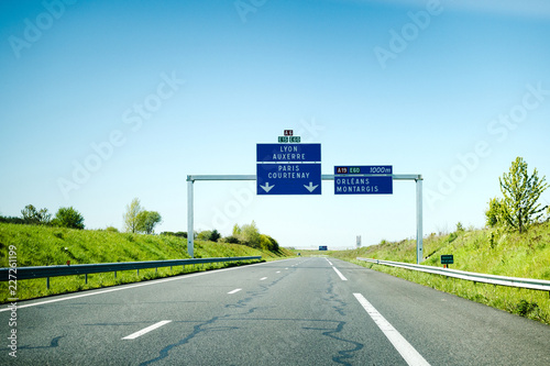 Empty French highway autoroute with blue signage to Lyon,Paris, Auxerre, Courtenay, Orleans, Montargis - holiday travel destination to central France
