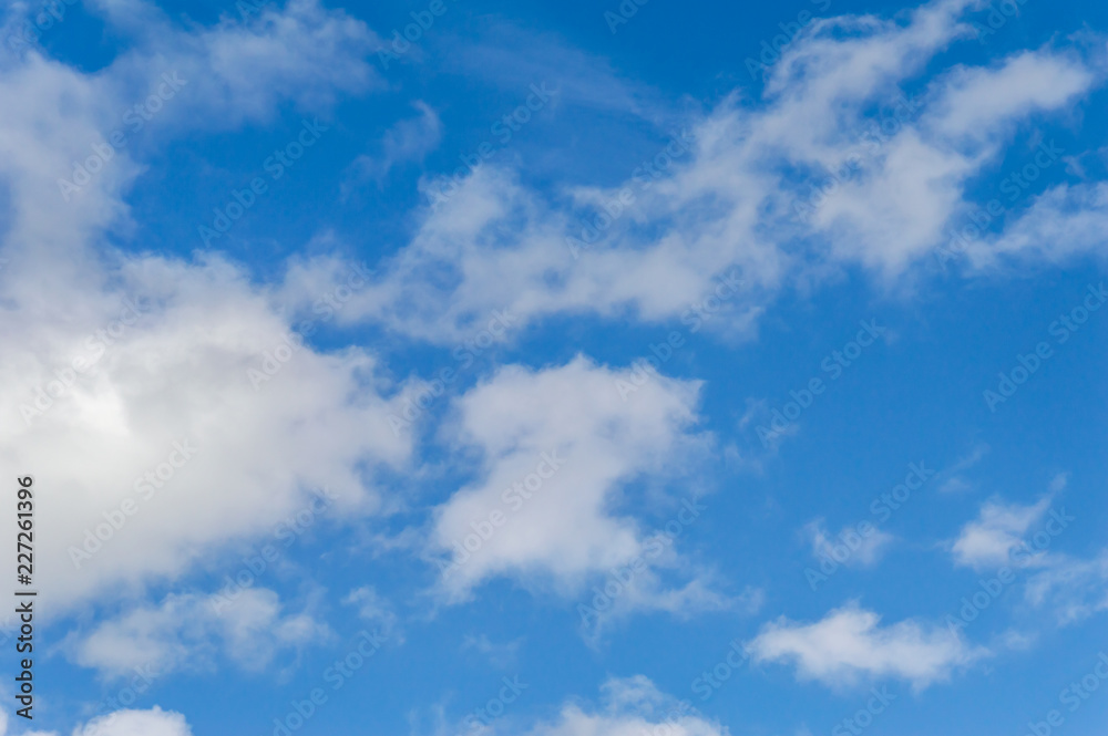 A deep blue sky with scattered clouds
