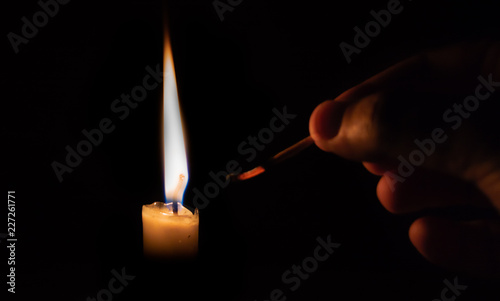 Person lighting a candle with a matchstick. extinguised matchstick