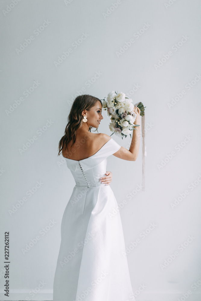 A concept wedding, contemporary European bride. Bouquet of flowers, fees in the interior Studio. Ideas for a minimalist wedding, white color