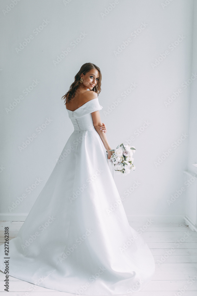 A concept wedding, contemporary European bride. Bouquet of flowers, fees in the interior Studio. Ideas for a minimalist wedding, white color A concept wedding, contemporary European bride. Bouquet of flowers, fees in the interior Studio. Ideas for a minimalist wedding, white color