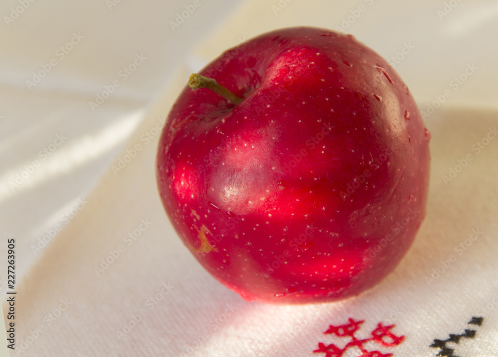 Ripe red Apple on linen napkin with embroidery