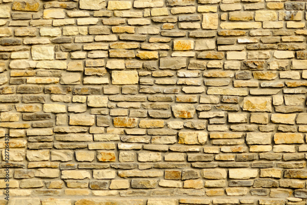 Close up of worn yellow granite rock stone wall