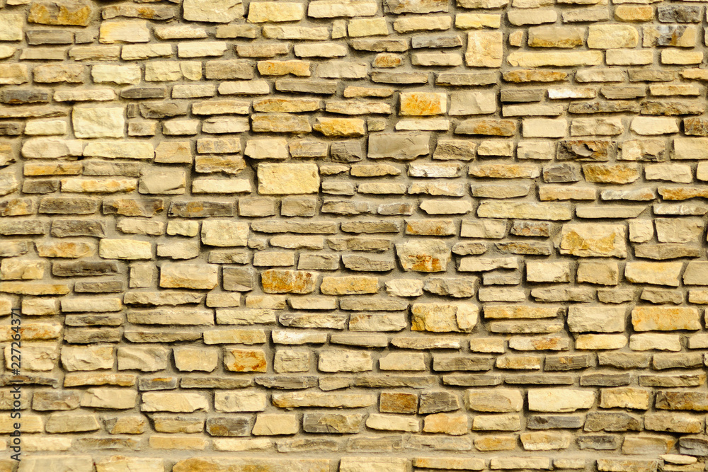 Fototapeta premium Close up of worn yellow granite rock stone wall