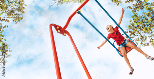 Happy smiling little girl swing on the swing