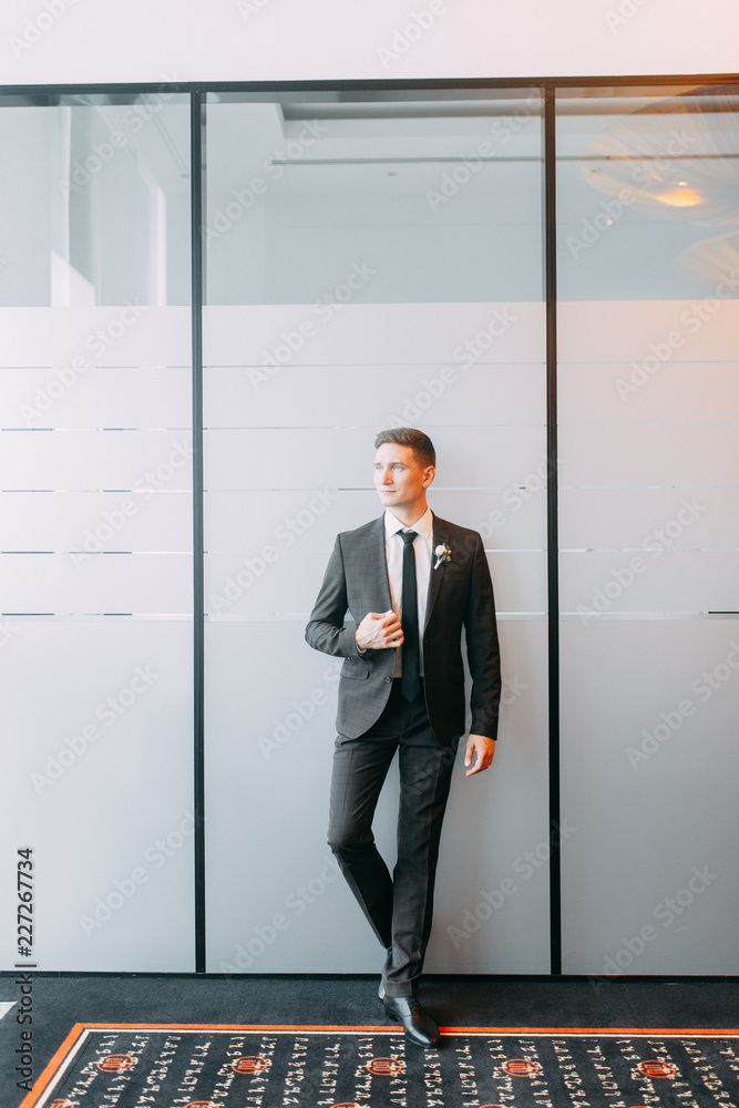 Fototapeta premium Stylish minimalism in the image of the groom. Black color and European wedding. The preparations of the groom, hotel