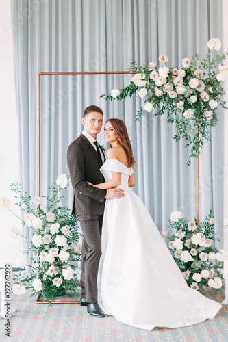 Stylish European wedding ceremony. The bride and groom are surrounded by guests. Arch and decor of fresh flowers. .Wedding ideas
