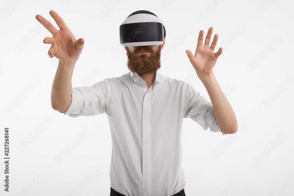 Augmented reality, innovations, programming and future concept. Unshaven male with stubble posing in studio wearing rift oculus 3d headset holding hands in front of him as of touching something