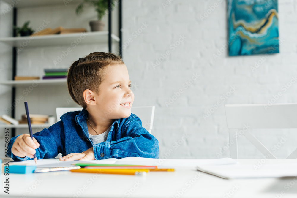 cute little kid drawing with color pencils at home and looking away cute little kid drawing with color pencils at home and looking away