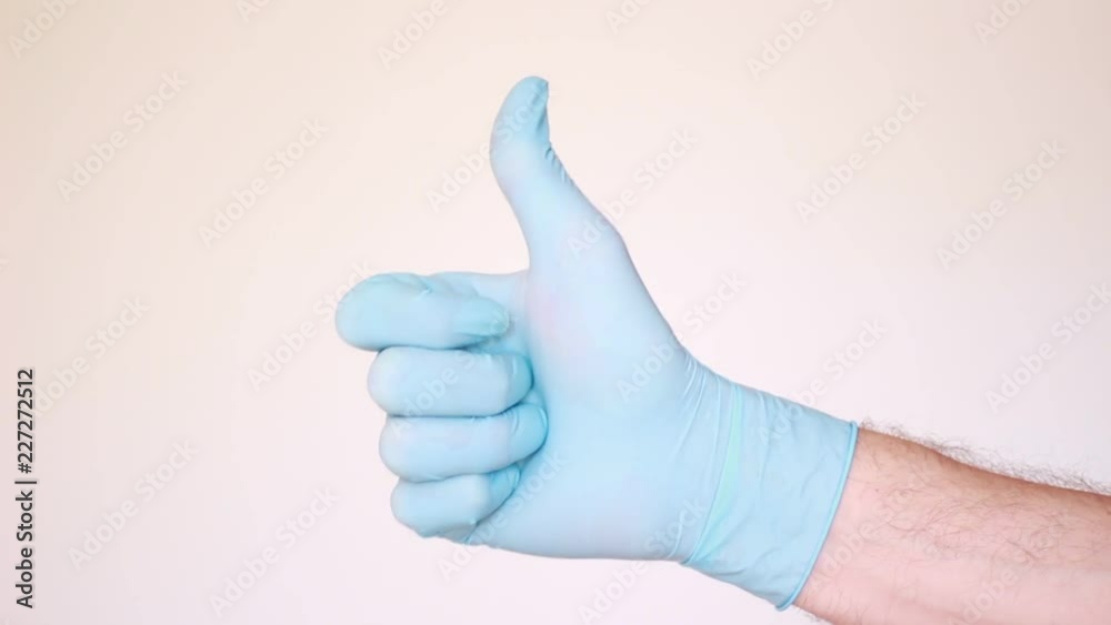 Male thumb in blue latex glove Male thumb in blue latex glove