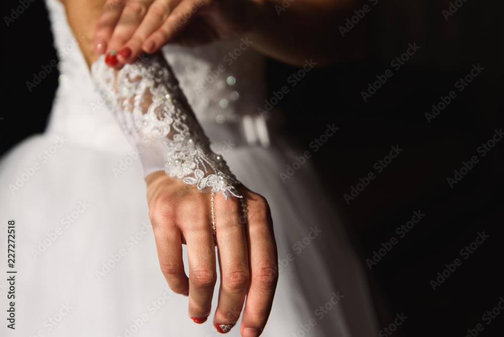 Hands of the bride in gloves