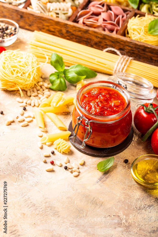 Food background with ingredients for italian healthy homemade classic spicy tomato pasta or pizza sauce with assorted pasta, pine nuts and basil. Copy space. Food background with ingredients for italian healthy homemade classic spicy tomato pasta or pizza sauce with assorted pasta, pine nuts and basil. Copy space.