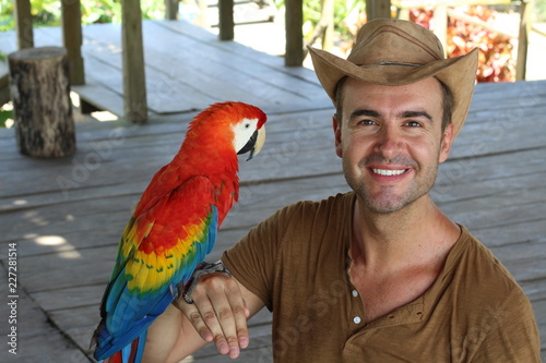 Handsome man interacting with a macaw