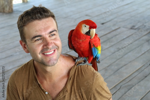 Handsome man holding and colourful macaw