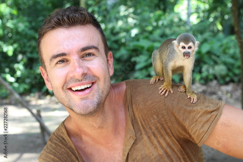 Photography Handsome man with titi monkey on his shoulder