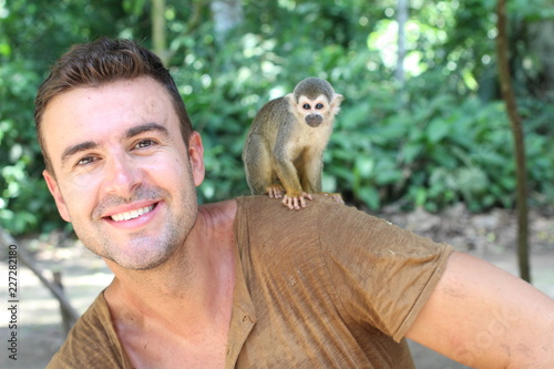 Photography Handsome man with titi monkey on his shoulder