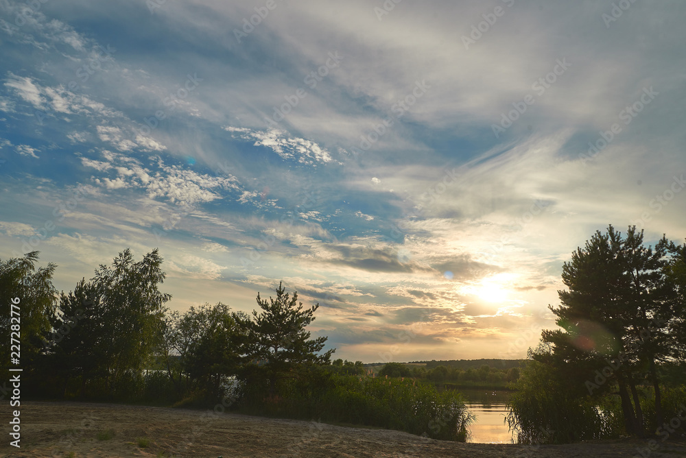 Sunset on the river is visible through the reeds. Sunset on the river is visible through the reeds.
