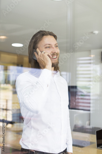 Happy young man using his s...