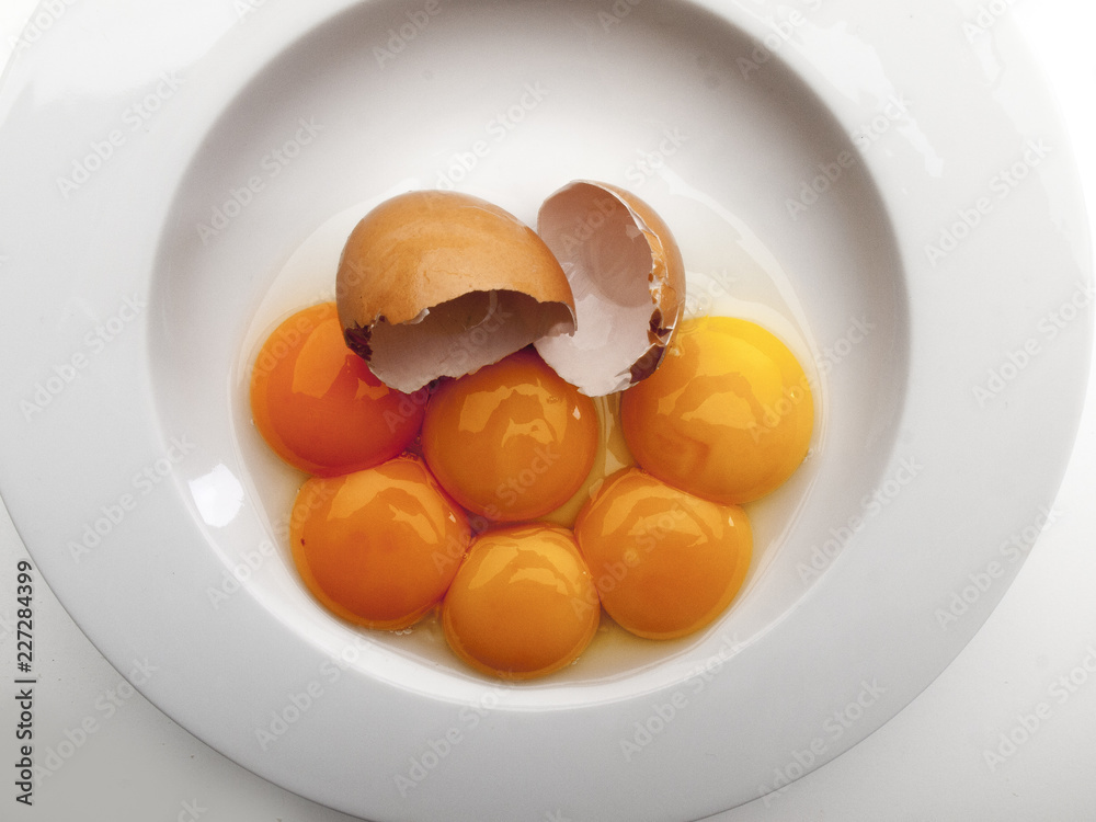 Varios huevos rotos dentro de un plato redondo blanco vista cenital Varios huevos rotos dentro de un plato redondo blanco vista cenital