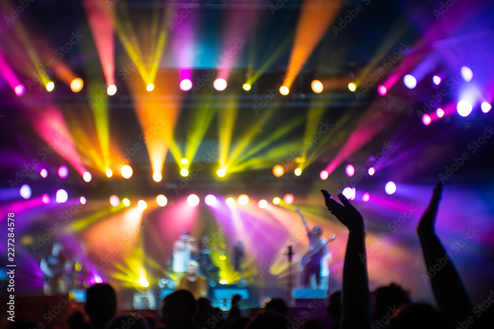 Abstraction with blurry musicians on stage full of colorful stage lights during the concert