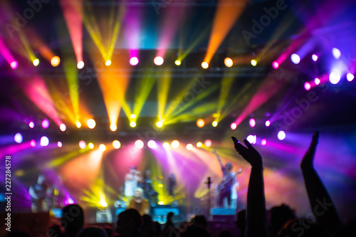 Abstraction with blurry musicians on stage full of colorful stage lights during the concert