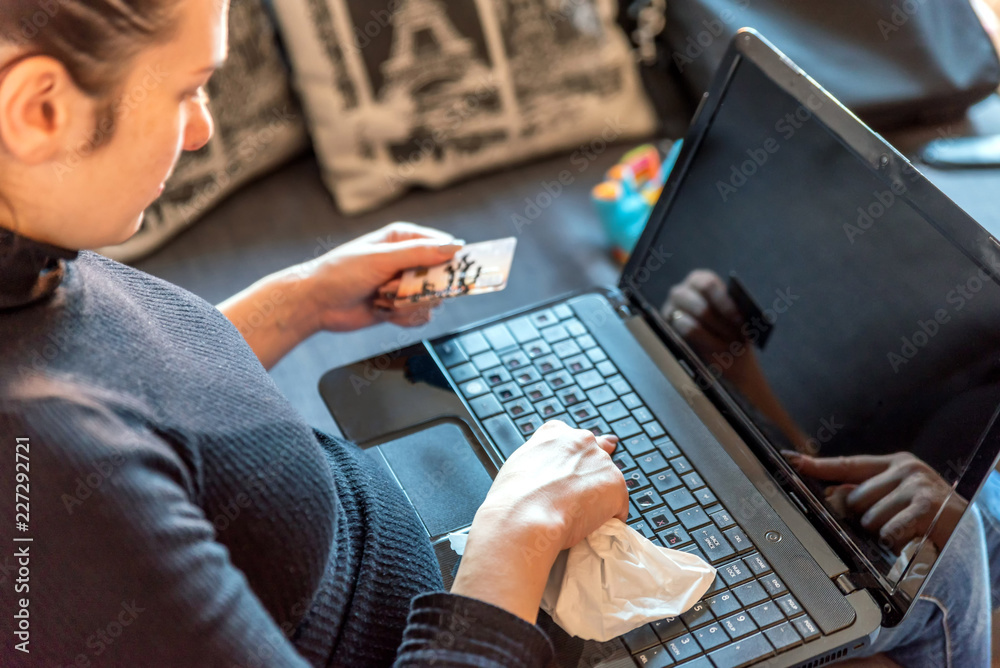 young sick woman at home paying for mdeicines on laptop next to medicines young sick woman at home paying for mdeicines on laptop next to medicines